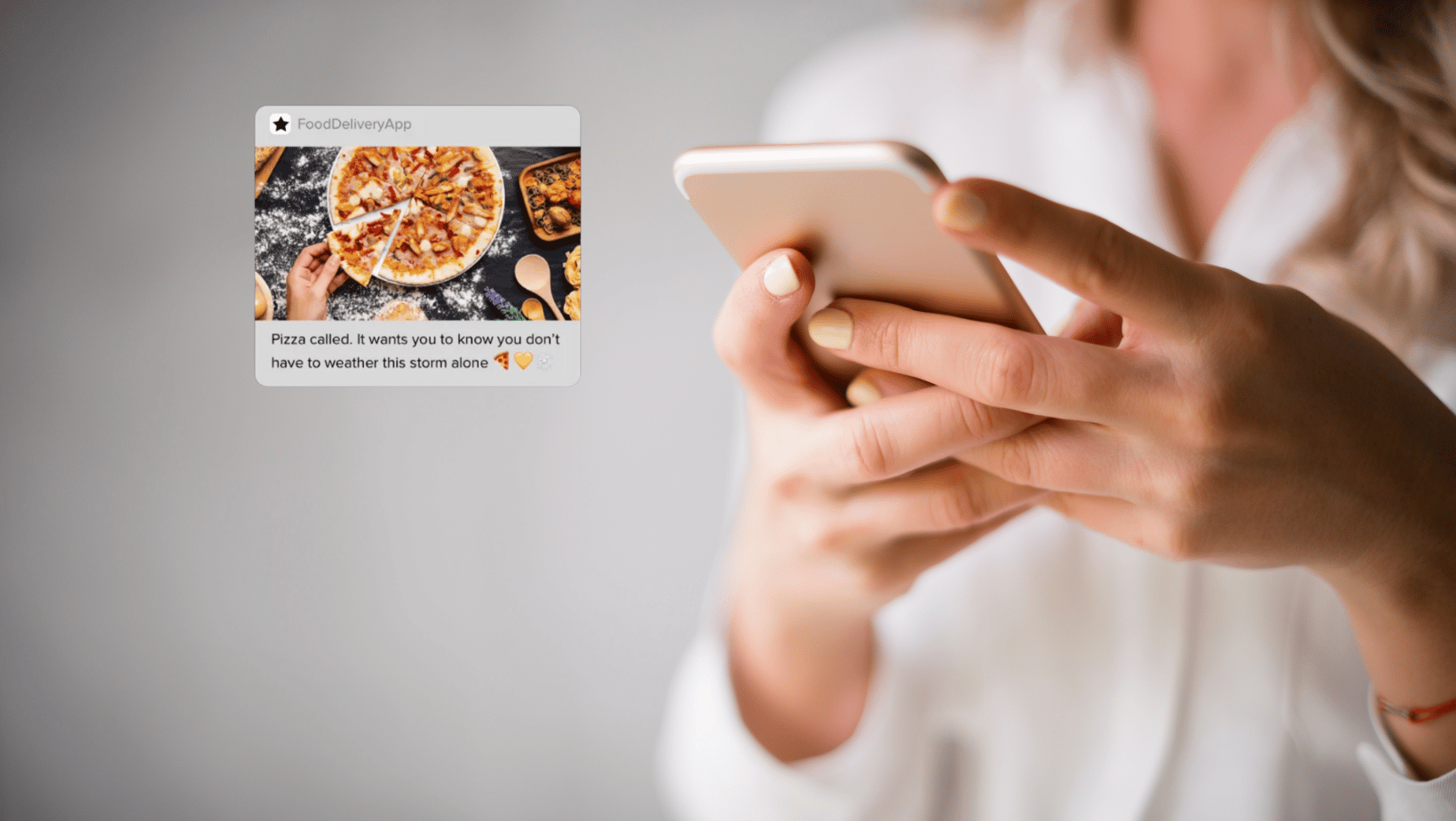 Girl holding phone gets push notification from pizza estaurant.