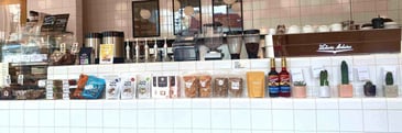 A coffee bar with syrups, coffee beans, and tea