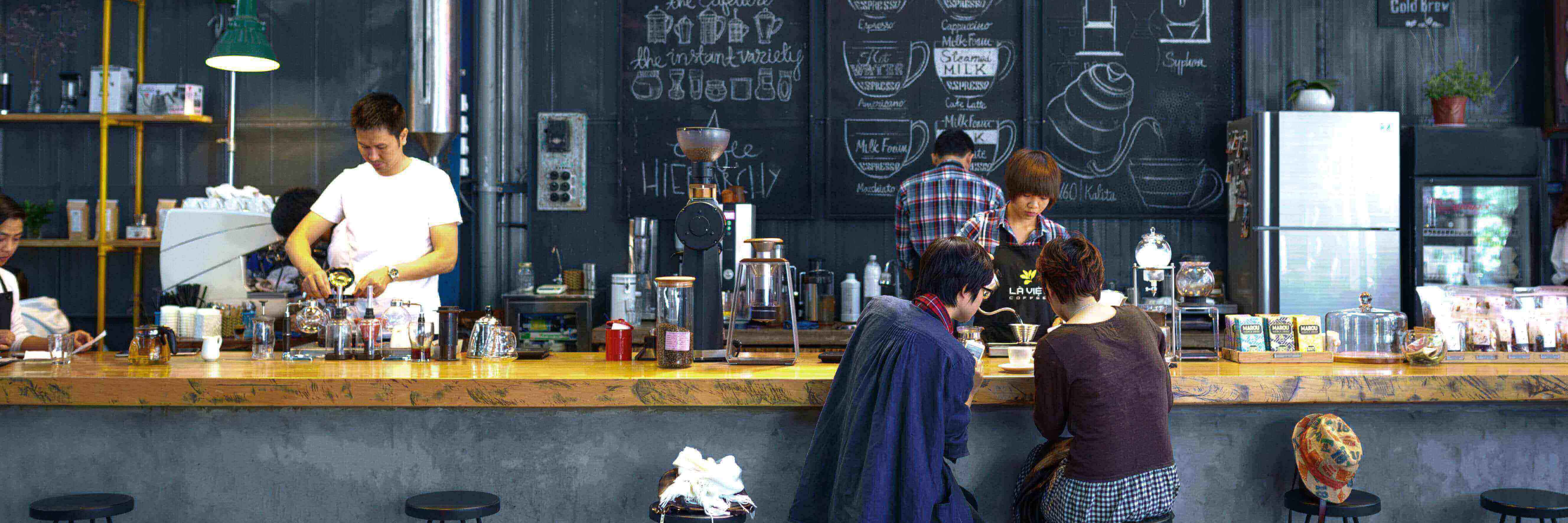 Baristas behind the bar preparing orders for customers