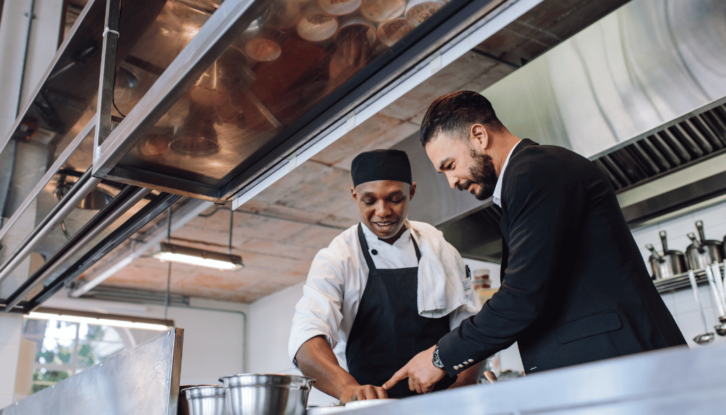 Restaurant manager with chef in kitchen.