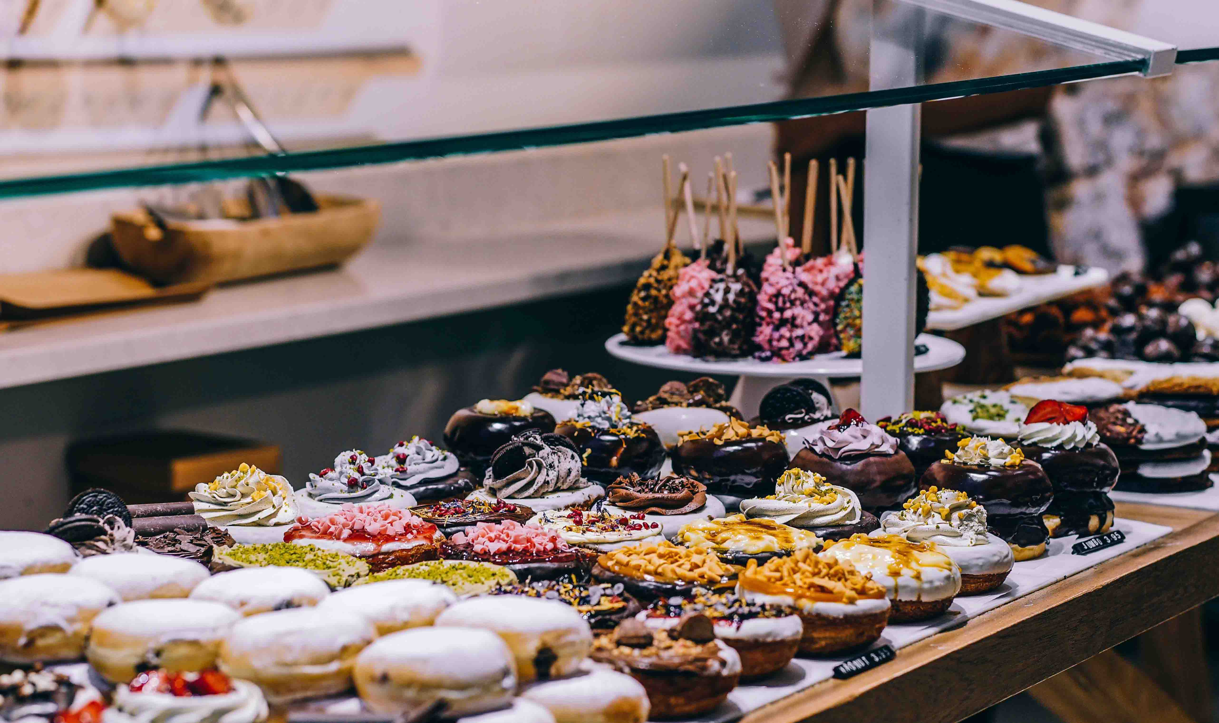 A bunch of donuts at the front counter of a bakery