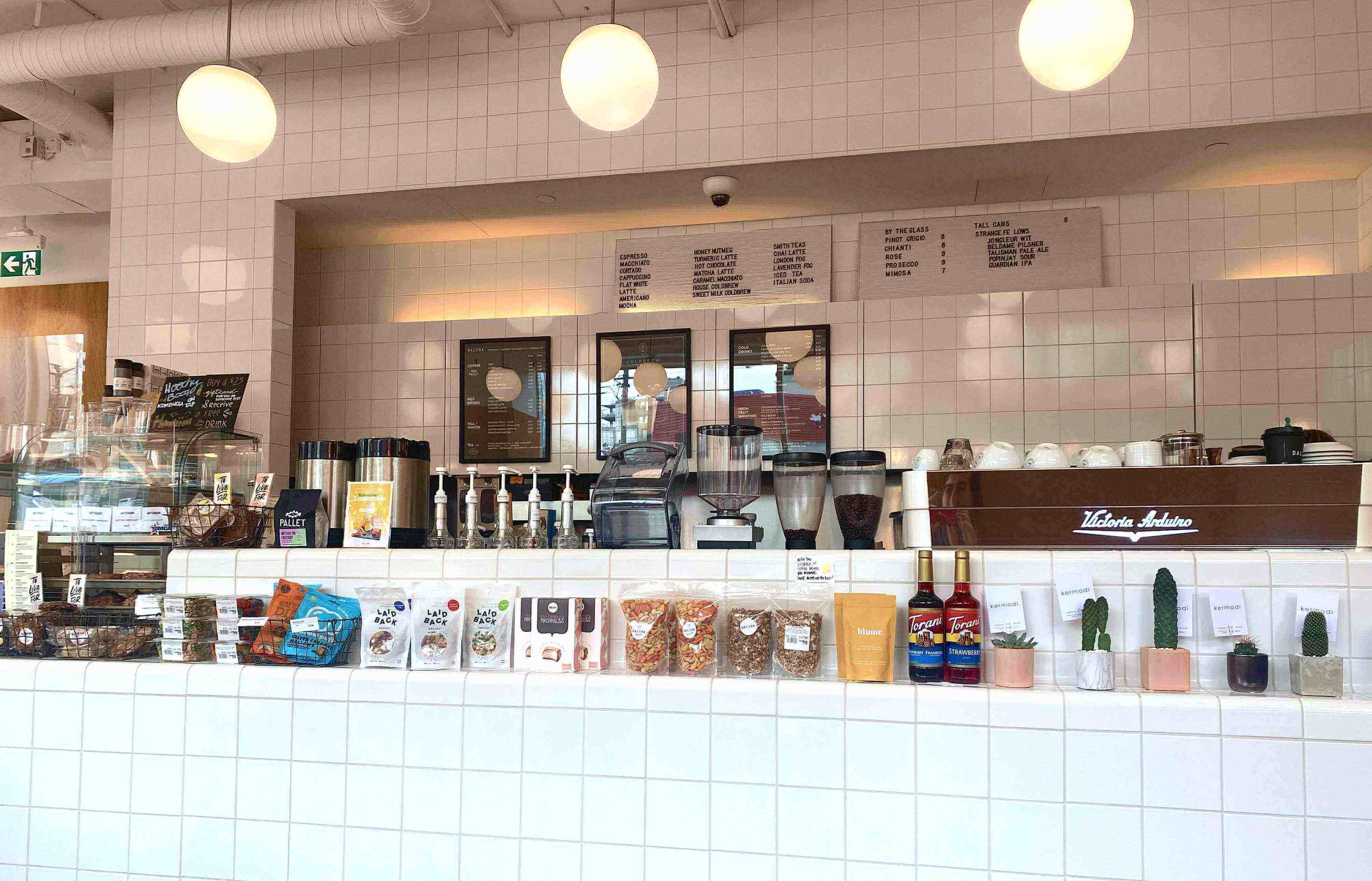A coffee shop with syrups on the counter