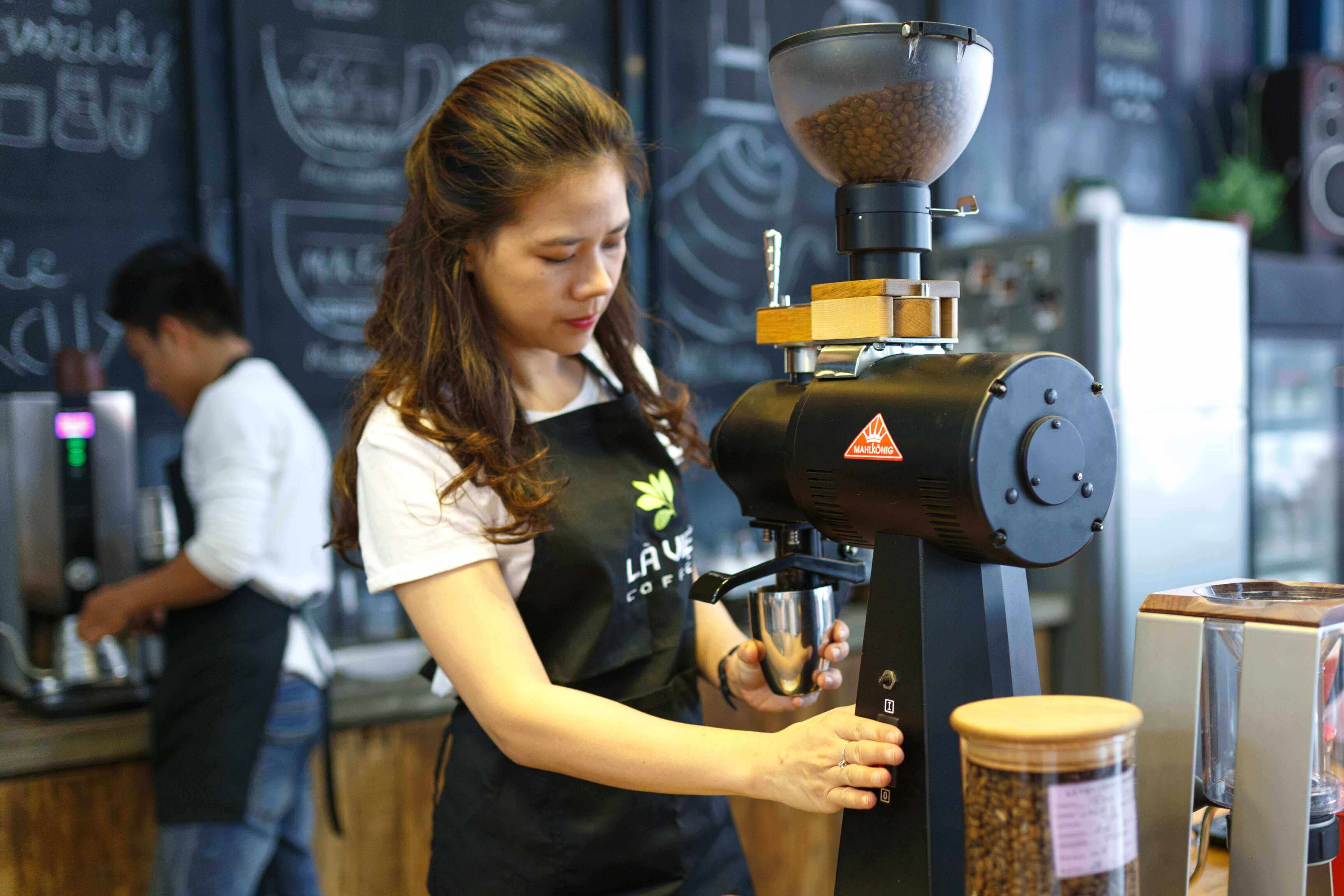 A coffee shop employee making an espresso