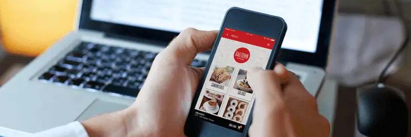 A person holding a phone with a restaurant ordering app open