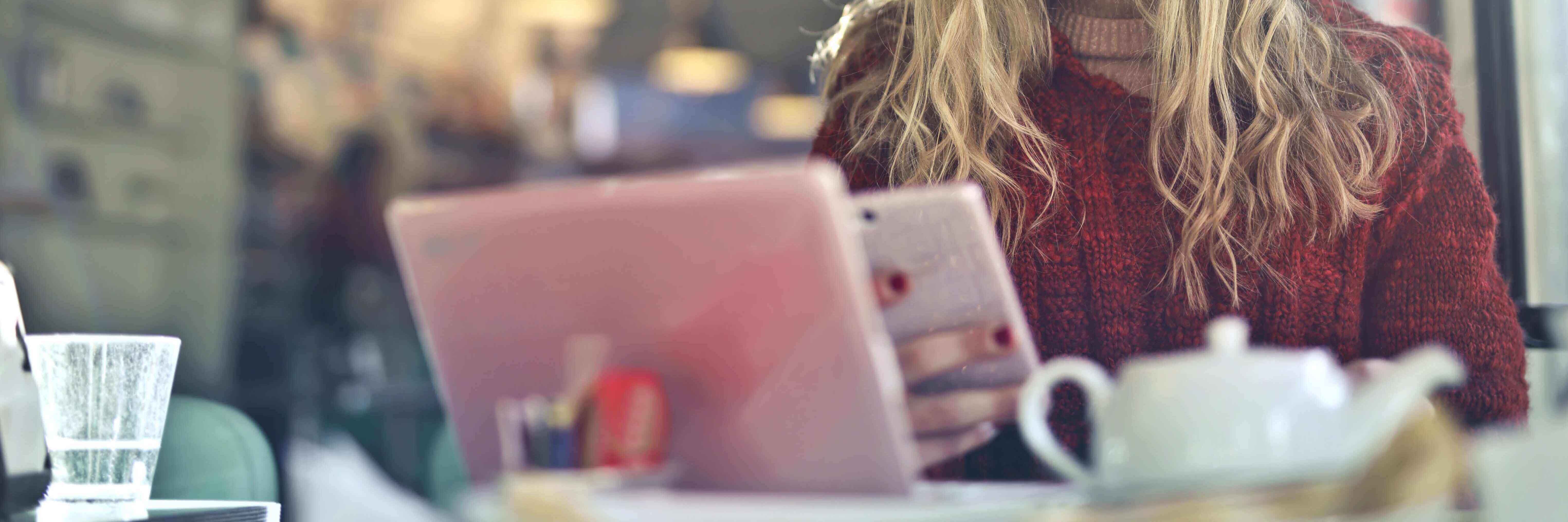 A phone, and laptop at a coffee shop table