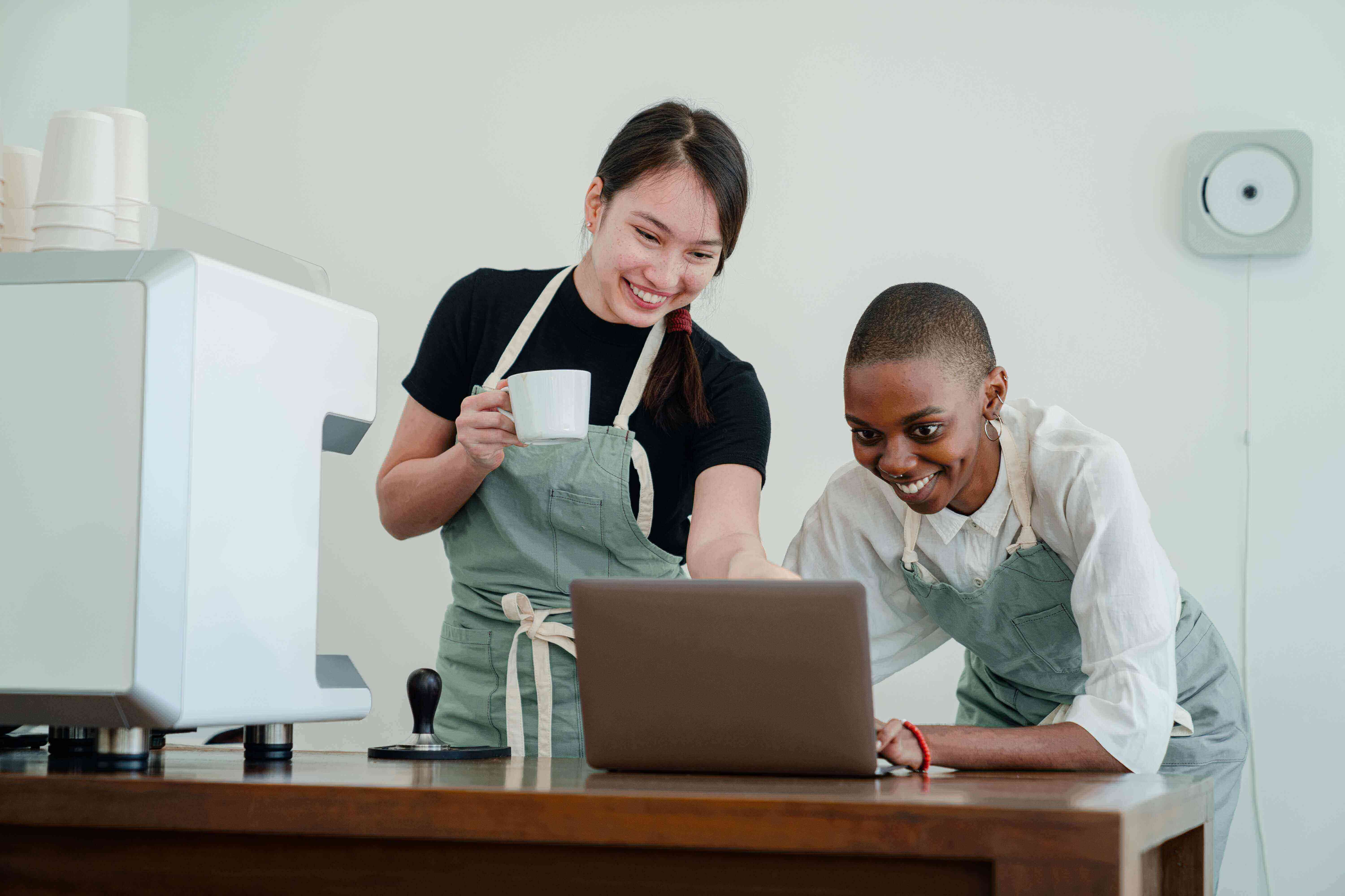 Two coffee shop employees looking at a computer